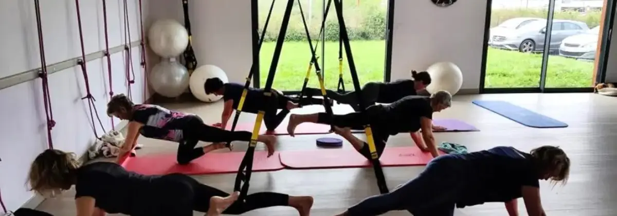Cours collectif en salle, travail au sol sur tapis