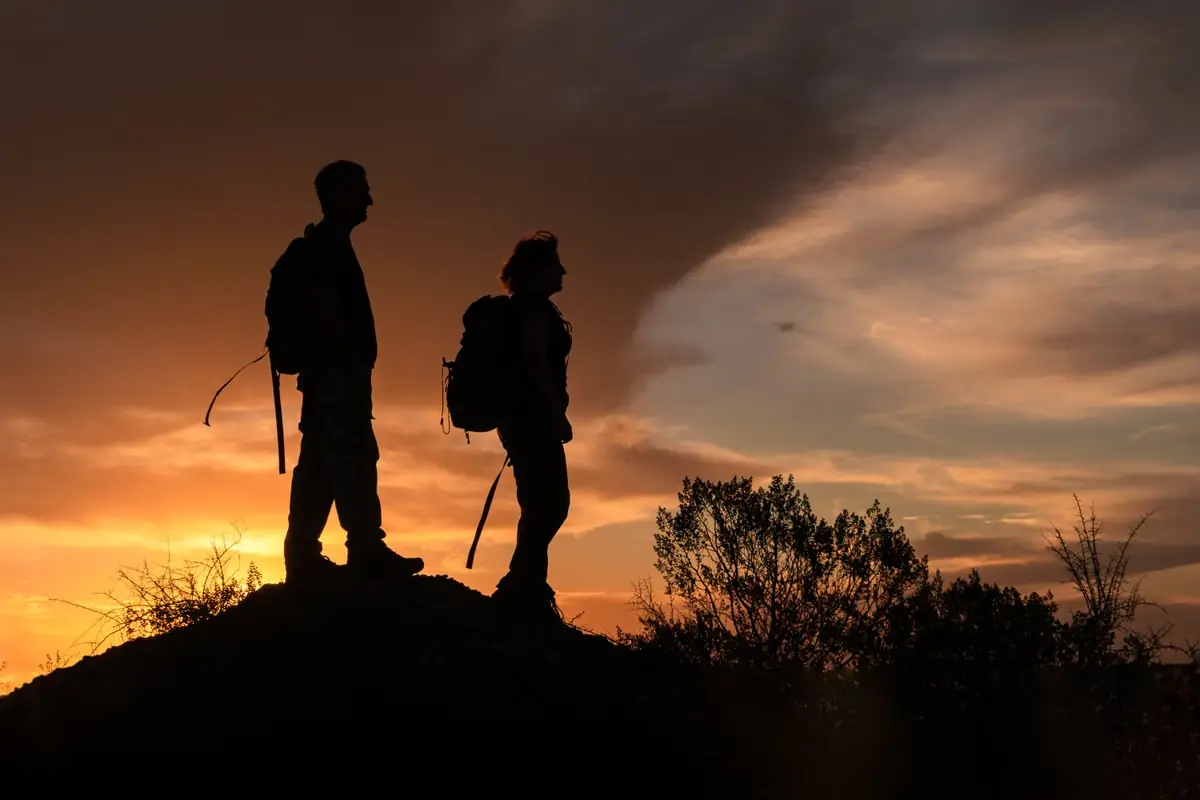 Randonneurs arrivant ensemble au sommet au coucher du soleil